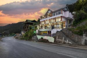 a house on the side of a hill with a street at Narkanda Heights by Splendid Retreat Hotels in Nārkanda