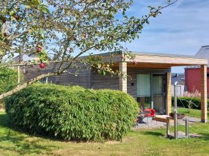 a house with a large bush in front of it at Gartenlodge im Grünen in Feuerscheid