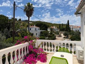 a balcony with pink flowers and a palm tree at Condillia II in Spetses