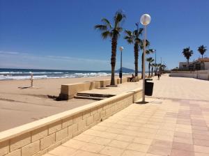a sidewalk on a beach with palm trees and the ocean at Ca Bienvenida in Miramar