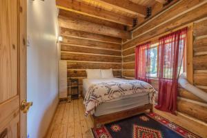 ein Schlafzimmer mit einem Bett in einer Blockhütte in der Unterkunft Adams Rest in The Dalles