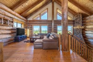 ein Wohnzimmer mit Couch und Fernseher in einer Blockhütte in der Unterkunft Adams Rest in The Dalles