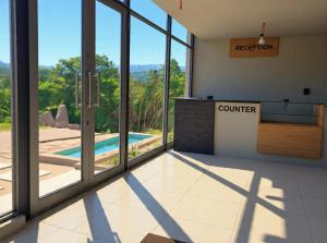 a room with a view of a pool through glass at Questro Apartment Hotel in eNyamazaneni