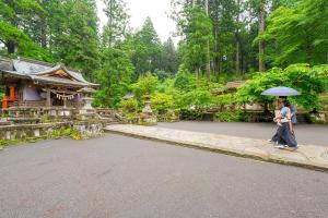 a couple walking down a street with an umbrella at Yufuin Ryokan Yufumomiji in Yufu