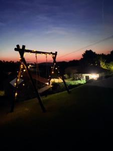 a swing in a yard with lights at night at CASA DO CONDE MONTIER in Paredes de Coura