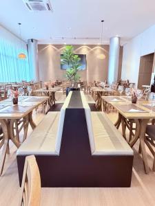 a dining room with wooden tables and chairs and a sidx sidx sidx sidx at SOFISTICADO Flat Brasília no Eixo Monumental, Melhor Localização de Brasília in Brasília