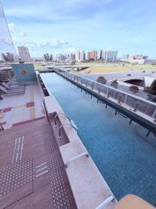 a pool of water with benches on a building at SOFISTICADO Flat Brasília no Eixo Monumental, Melhor Localização de Brasília in Brasília
