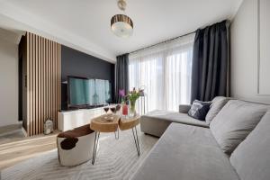 a living room with a couch and a table at Luxury Heaven Apartment - 116 m2 Fireplace 3 bedroom - Free Parking in Katowice