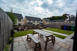a picnic table and benches on a patio at Spacious 5BR Home St Andrews in Fife