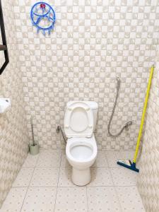 a bathroom with a toilet and a mop at Home23 Apartments in Jinja +17 photos