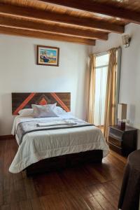 a bedroom with a large bed and a window at Hostal Catequil in Cajamarca