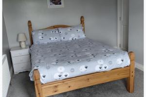 a bedroom with a bed with a wooden bed frame at Cottage - Sleeps 6 - Parking in Letterkenny