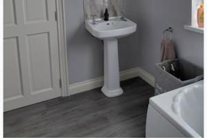 a bathroom with a white sink and a white door at Cottage - Sleeps 6 - Parking in Letterkenny +9 photos