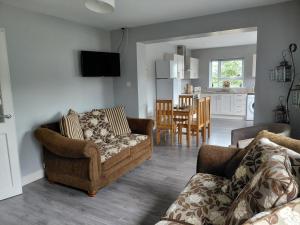 a living room with two couches and a kitchen at Cottage - Sleeps 6 - Parking in Letterkenny