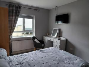 a bedroom with a bed and a dresser and a window at Cottage - Sleeps 6 - Parking in Letterkenny