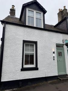 a white house with a window and a green door at Modern 3BR home in Cumbernauld in Cumbernauld