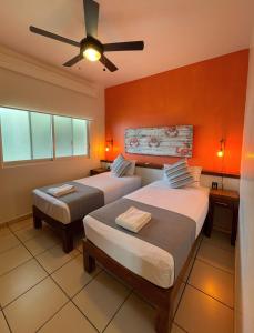 a bedroom with two beds and a ceiling fan at Punto Mita Eco Surf Suites in Punta Mita