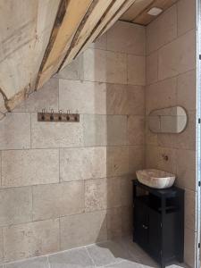 a bathroom with a sink and a stone wall at Le gîte du parayre in Lunac +21 photos