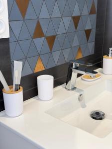 a bathroom counter with a sink with toothbrushes at Suite indépendante proche Bordeaux in Rions +12 photos