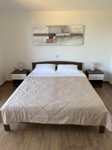 a bedroom with a bed with two nightstands and two tables at Apartment Sidro in Posedarje