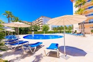 a swimming pool with lounge chairs and umbrellas at Rentalmar Pineda Suites in La Pineda