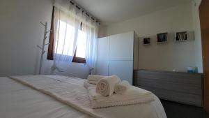 a bedroom with a bed with towels on it at Il Tramonto in Elmas