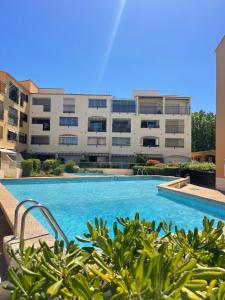 a swimming pool in front of a building at loft appartement in Cap d'Agde