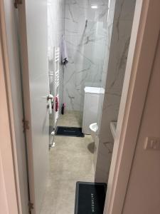 a bathroom with white marble walls and a toilet at Modern Apartment Laktaši in Laktaši +4 photos
