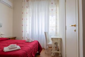 a bedroom with a red bed and a desk and a window at Little Garden in Formia