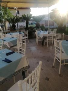 a restaurant with white tables and white chairs at Little Garden in Formia