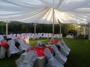 a group of tables and chairs under a white tent at Little Garden in Formia