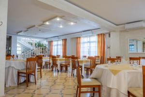 a dining room with tables and chairs and windows at Little Garden in Formia