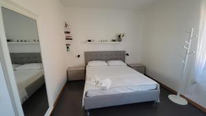 a small room with a bed and a mirror at Il Tramonto in Elmas
