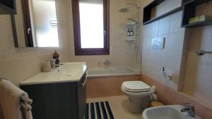 a bathroom with a sink and a toilet and a tub at Il Tramonto in Elmas