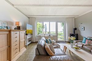 a living room with a couch and a large window at Ferienhaus Marienleuchte in Marienleuchte