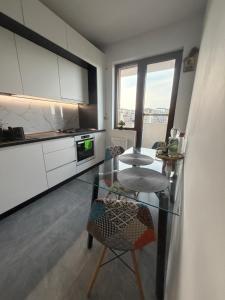 a kitchen with a glass table and some chairs at Royal Five Urban in Bucharest