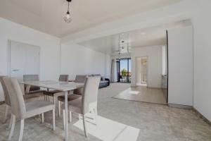 a dining room with white walls and a table and chairs at Complex PopDan in Costinesti