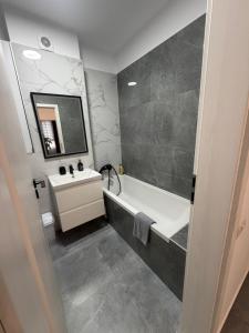 a bathroom with a tub and a sink and a mirror at Royal Five Urban in Bucharest +8 photos