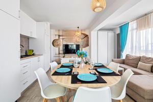 a kitchen and living room with a table and chairs at Bavaro 50 by Alezzi Resort in Mamaia Sat/Năvodari +4 photos