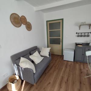 a living room with a gray couch and wooden floors at Charme a Corniglio - Suite Cervo in Corniglio