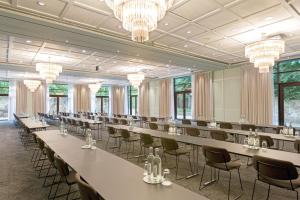 a row of tables and chairs in a room with chandeliers at Hotel Remarque in Osnabrück