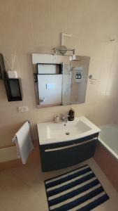 a bathroom with a sink and a mirror and a tub at Il Tramonto in Elmas +3 photos