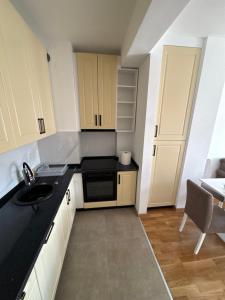 a small kitchen with a sink and a stove at Modern Apartment Laktaši in Laktaši