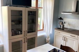a white cabinet with glass doors in a kitchen at Cascina Vica Biella in Andorno Micca +30 photos