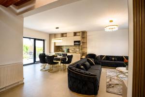 a living room with a couch and a table with chairs at Cataleya House Sovata in Sovata