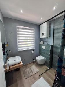 a bathroom with a toilet and a glass shower at Apartmani San Snova in Kotor-Varoš +60 photos