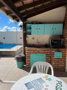a patio with a table and chairs and a kitchen at Pousada da Igreja in Pântano Grande