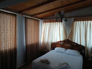 a bedroom with a bed with white sheets and a window at Johnny Apartment Berat in Berat +12 photos