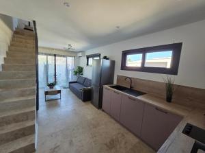 a kitchen and living room with a refrigerator and a staircase at La Casadrine in Le Grau-dʼAgde