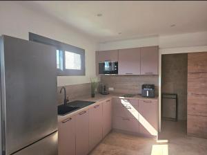 a kitchen with white cabinets and a sink and a window at La Casadrine in Le Grau-dʼAgde